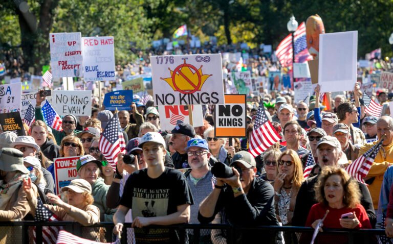 Protesters wave banners at the No Kings rally on Boston Common. (Robin Lubbock/WBUR)